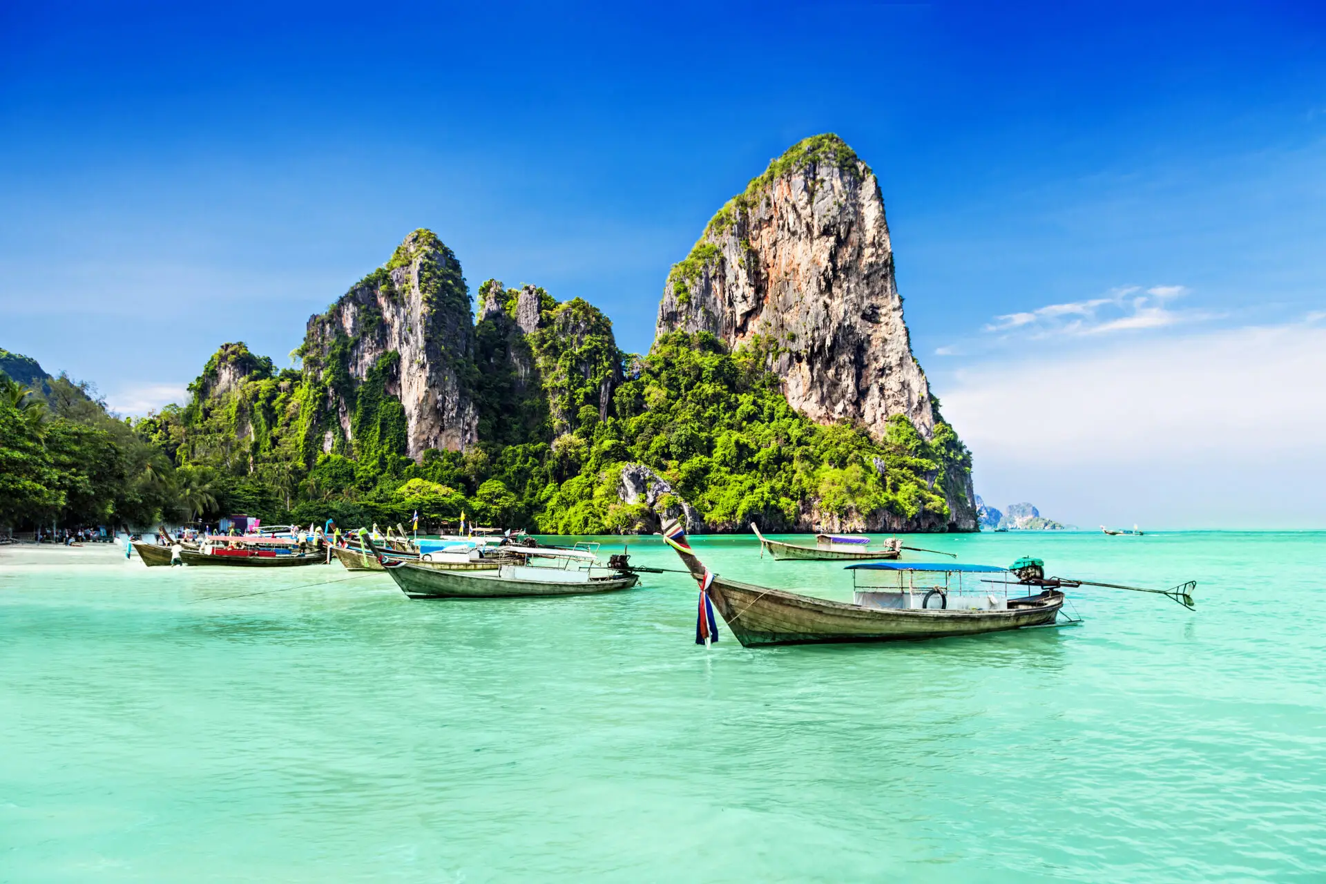 Beautiful turquoise water with traditional boats in Thailand